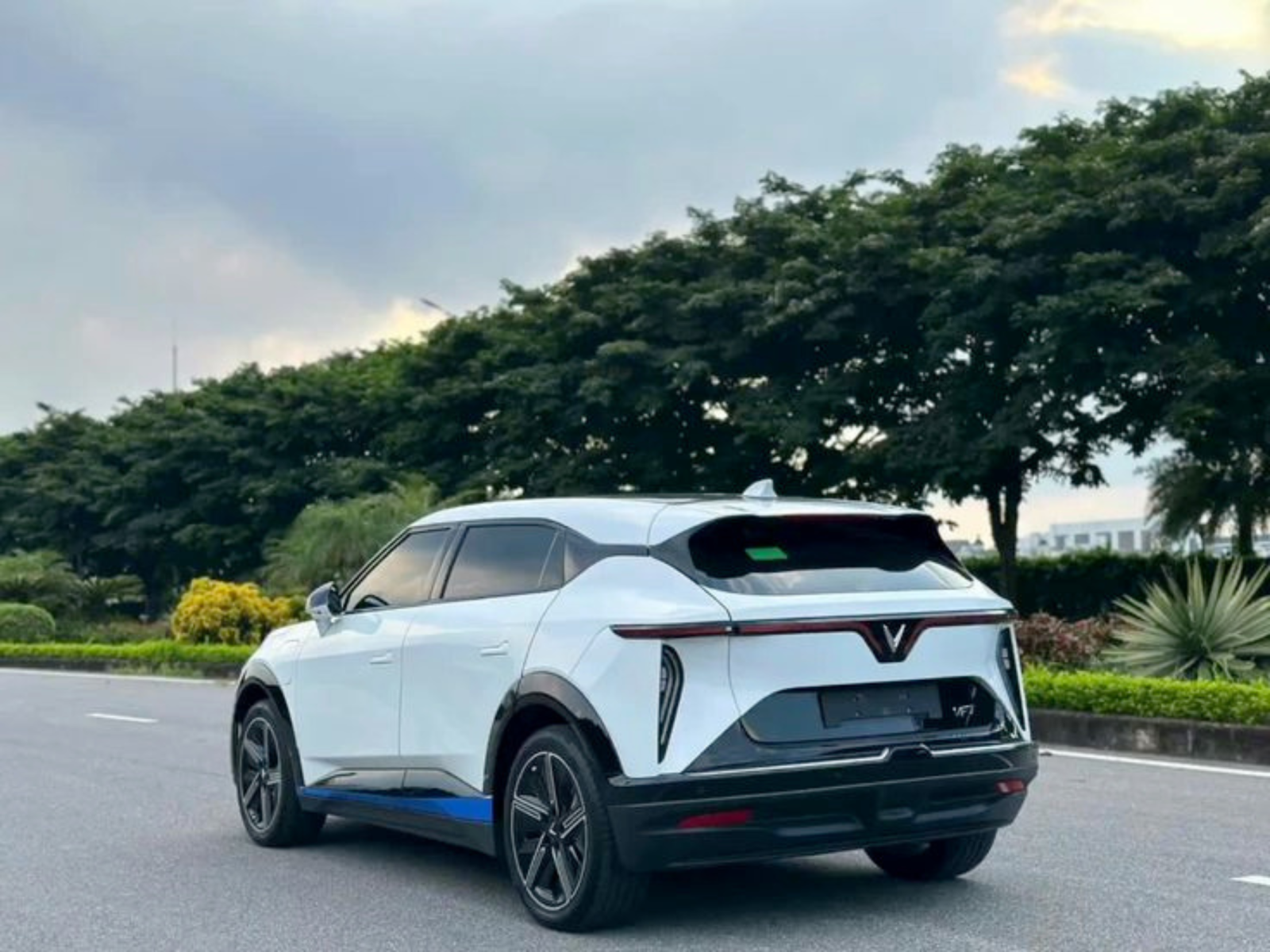 VinFast VF 7 màu trắng nhìn từ góc phía sau trong khung cảnh ngoài trời